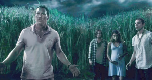 Ross Humboldt bersama Becky DeMuth, Travis McKean, dan Cal DeMuth berada di tengah ladang rumput tinggi yang membingungkan dalam film In the Tall Grass